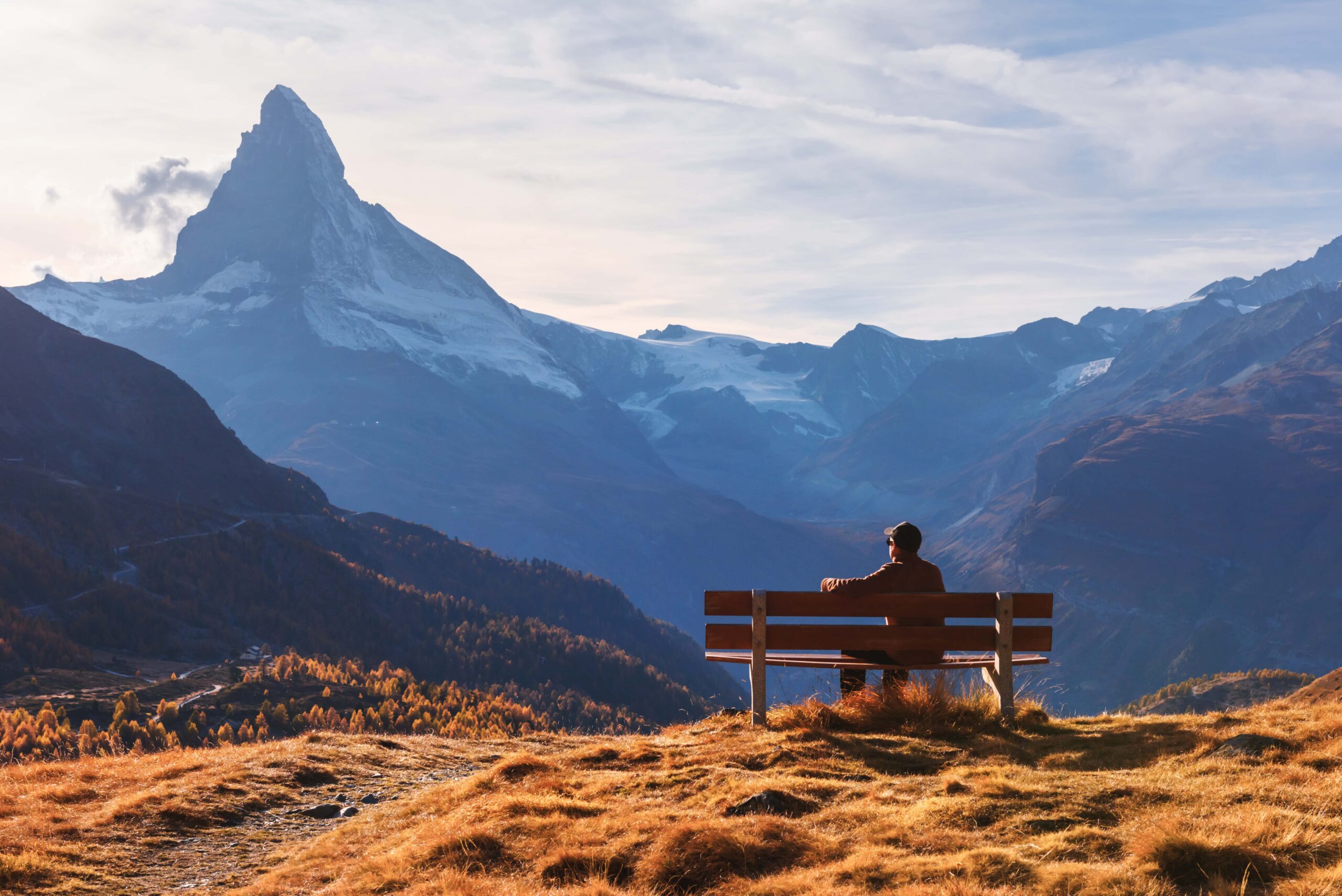 Ein Mann sitzt auf einer Bank und bewundert die malerische Aussicht auf das Matterhorn.